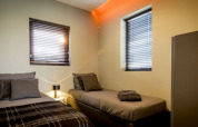 Moderne lodgekamer bij Modus in Bad Hoophuizen, Nederland, met twee eenpersoonsbedden en ramen.
