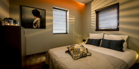 Gezellige slaapkamer bij Modus, Bad Hoophuizen, Nederland, met tweepersoonsbed en zonlicht op de muur.