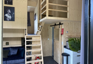 Innenraum eines Tiny House bei Bad Hoophuizen in den Niederlanden mit Holzdekor und kleinem Loft.