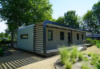 Moderne lodge Modus XL in het groen, met stijlvolle gevel en ruime ramen in de natuur.