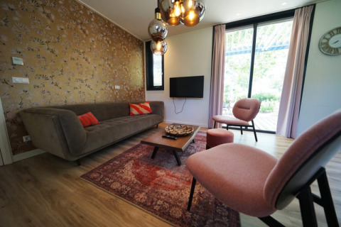 Salón elegante en el lodge Modus XL de Bad Hoophuizen, Países Bajos, con muebles y decoración modernos.