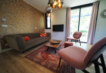 Salón elegante en el lodge Modus XL de Bad Hoophuizen, Países Bajos, con muebles y decoración modernos.