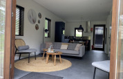 Vista interior de una moderna cabaña en Modus, Bad Hoophuizen, Países Bajos, con salón elegante.