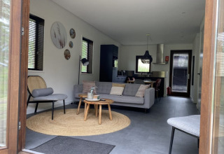 Interieurbeeld van een moderne lodge bij Modus, Bad Hoophuizen, met een stijlvolle woonkamer en keuken.