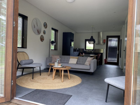 Vista interior de una moderna cabaña en Modus, Bad Hoophuizen, Países Bajos, con salón elegante.