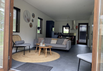 Vista interior de una moderna cabaña en Modus, Bad Hoophuizen, Países Bajos, con salón elegante.