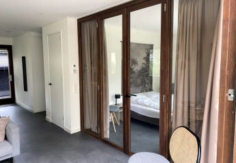 Lodge moderno al Modus di Bad Hoophuizen, Paesi Bassi, con porte in vetro, camera e arredo elegante.