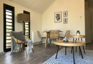 Soggiorno moderno in lodge al Beach House di Bad Hoophuizen, Paesi Bassi, con zona pranzo e arredamento naturale.