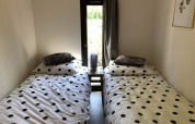 Camas individuales con ropa de cama de lunares junto a una ventana en Beach House en Bad Hoophuizen.