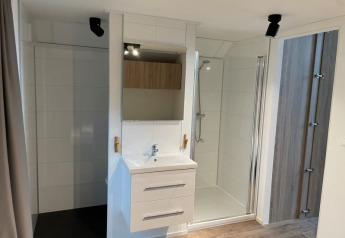 Modern badkamerinterieur in Tiny Beach House, Bad Hoophuizen, Nederland, met douche en wastafel.