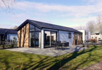Moderne Velthorst-Lodge mit großen Fenstern, Terrasse und Garten in ruhiger, natürlicher Umgebung.
