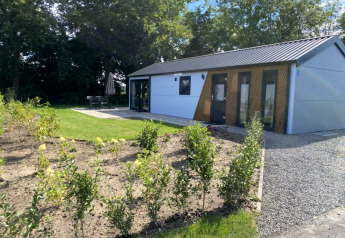 Moderne Velthorst-Lodge in Bad Hoophuizen, Niederlande, mit Garten, Terrasse und grüner Umgebung.