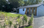 Moderne Velthorst lodge bij Bad Hoophuizen in Nederland met tuin, terras en omringd door veel groen.