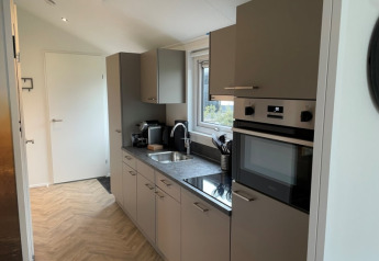Interno cucina moderna in un lodge a Velthorst, Bad Hoophuizen, Paesi Bassi, con finestra e elettrodomestici.