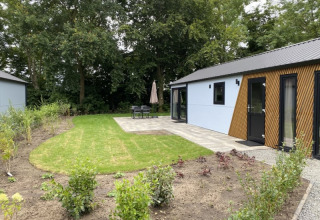Udendørsbillede af Velthorst-lodge ved Bad Hoophuizen i Nederlandene, med græsplæne og terrasse.