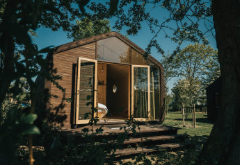 Wikkel tiny house met open glazen deuren en houten gevel in Holiday park De Klepperstee, Nederland.