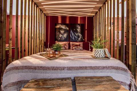 Interno camera da letto moderna al Modus Wellness, Bad Hoophuizen, con legno e ritratti artistici alle pareti.