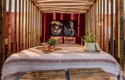 Moderne slaapkamer bij Modus Wellness, Bad Hoophuizen, met houten accenten en kunstzinnige portretten.