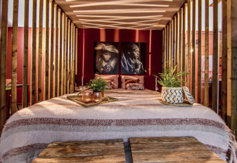 Modern bedroom interior at Modus Wellness, Bad Hoophuizen, featuring wood accents and artistic portraits.