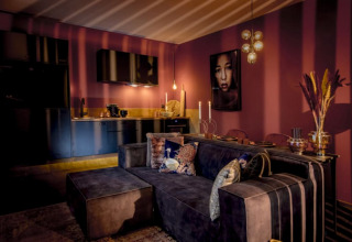 Salón y cocina modernos en Modus Wellness, Bad Hoophuizen, Países Bajos, con iluminación acogedora.