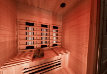 Infrared sauna with wooden benches and rolled towels at Modus Wellness, Bad Hoophuizen, Netherlands.