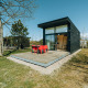 Moderne sort tiny house med stor glasfacade og terrasse, beliggende i grøn natur ved De Klepperstee, Holland.