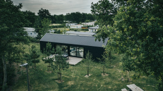 Lodge bij t Kroaje op vakantiepark De Klepperstee in Nederland, omringd door bomen en groene velden.