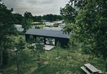 Lodge bij t Kroaje op vakantiepark De Klepperstee in Nederland, omringd door bomen en groene velden.