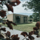 Et moderne lodgehus blandt træer og græsarealer i Holiday park De Klepperstee, Ouddorp, Holland.