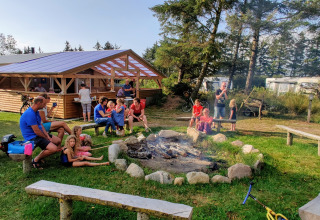 Families and children enjoy time around a campfire at Ballum Camping, a holiday park in Southern Denmark.