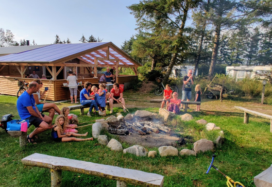 Familles et enfants réunis autour d’un feu de camp à Ballum Camping, parc de vacances au sud du Danemark.