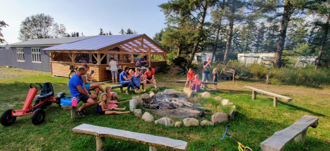 Familles et enfants réunis autour d’un feu de camp à Ballum Camping, parc de vacances au sud du Danemark.