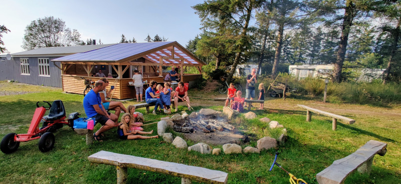 Familles et enfants réunis autour d’un feu de camp à Ballum Camping, parc de vacances au sud du Danemark.