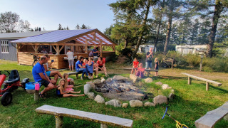 Familias y niños disfrutan junto a una fogata en Ballum Camping, un parque vacacional en el sur de Dinamarca.