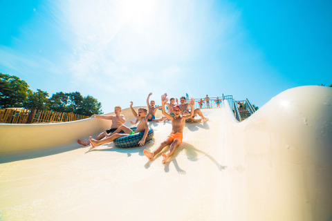 Kinderen glijden lachend van een waterglijbaan in het Papillon Country Resort in Overijssel, Nederland.