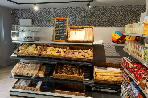 Bakery-afdeling in een winkel bij Papillon Country Resort, met broden, broodjes en sapjes op rekken.