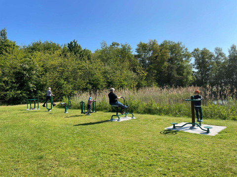 Buiten fitnessapparatuur en mensen die sporten op een zonnige dag in Papillon Country Resort, Overijssel.