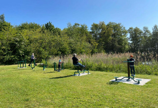 Buiten fitnessapparatuur en mensen die sporten op een zonnige dag in Papillon Country Resort, Overijssel.