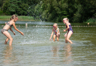 Drie kinderen spelen en spetteren vrolijk in het ondiepe water bij Papillon Country Resort in Overijssel.