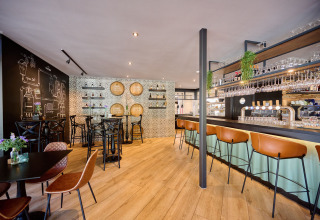 Gezellige bar en restaurantinterieur bij Papillon Country Resort, met houten vloer en moderne meubels.