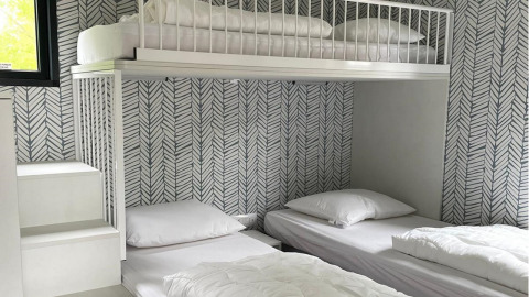 Moderne, compacte slaapkamer met hoogslaper en twee aparte bedden in Bungalow Cottage Prestige, Nederland.