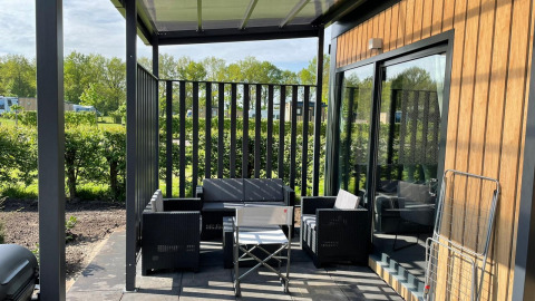 Buitenterras met moderne stoelen aan Bungalow Cottage Prestige op Papillon Country Resort in Nederland.