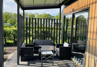 Buitenterras met moderne stoelen aan Bungalow Cottage Prestige op Papillon Country Resort in Nederland.
