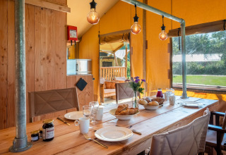 Indretning af Safari Tent Comfort på Papillon Country Resort i Holland med spisebord og morgenmad.