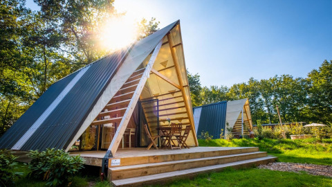 Moderna tiny house a forma di A al Papillon Country Resort nei Paesi Bassi, con terrazza soleggiata esterna.