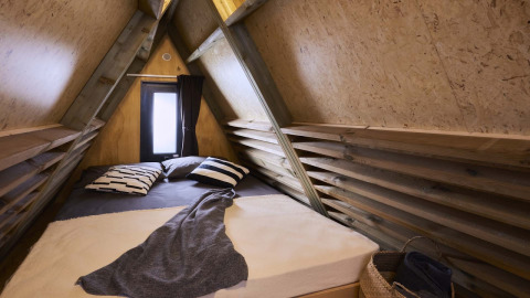 Cozy sleeping area inside an A-frame tiny house at Luxury Hottub Cabin, Papillon Country Resort, Netherlands.
