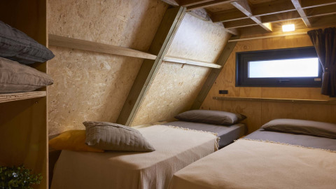 Gemütliches Schlafzimmer mit zwei Einzelbetten in einer Tiny House Hottub Cabin, Niederlande.