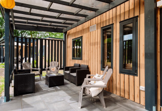Udendørs terrasse med moderne havemøbler og træbeklædning på Cottage Next XXL Family Deluxe ved Papillon Country Resort.