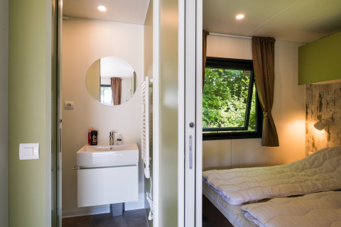 Cabaña moderna con dormitorio, baño y ventanales en Cottage Next XXL Family Deluxe, Papillon Country Resort, Países Bajos.
