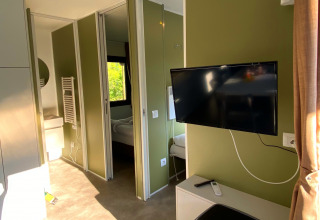 Innenansicht des Cottage Next XXL Family Deluxe im Papillon Country Resort mit Flachbildfernseher.